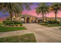 Charming single-story house with a brick driveway, stone-accented entrance, and tropical landscaping and palm trees at 568 Luna Bella Ln, New Smyrna Beach, FL 32168