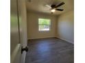 An empty bedroom with gray floors, a ceiling fan, and a sunlit window at 741 Ellen St, Daytona Beach, FL 32114