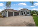 Charming home featuring a three-car garage, a well manicured lawn and lovely tropical landscaping at 3345 Tesoro Cir, New Smyrna Beach, FL 32168