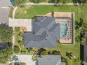 Aerial view of a beautiful home with a screened-in pool, landscaped yard, and patterned driveway at 3615 Marisol Ct, New Smyrna Beach, FL 32168