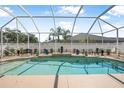 A private screened-in pool is surrounded by tasteful decor and a white privacy fence at 3615 Marisol Ct, New Smyrna Beach, FL 32168