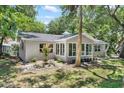Charming single-story home featuring mature trees, lush green lawn and a cozy enclosed porch at 4901 Sailfish Dr, Ponce Inlet, FL 32127