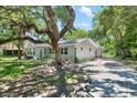 Charming single-story home featuring mature trees, lush green lawn and a paved driveway at 4901 Sailfish Dr, Ponce Inlet, FL 32127