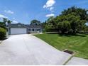 Exterior view of this house with a sprawling driveway and mature trees at 516 Spotted Sandpiper Dr, Daytona Beach, FL 32119