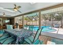 Enclosed lanai with dining set overlooking the pool and backyard, perfect for outdoor dining at 934 Tall Pine Dr, Port Orange, FL 32127