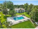 Community pool surrounded by manicured lawns and mature trees offering a great place to relax at 1 Tomoka Oaks Blvd # 135, Ormond Beach, FL 32174