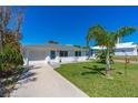Inviting home showcasing a lush lawn, complemented by mature trees and a well-kept exterior at 129 Dundee Rd, Daytona Beach, FL 32118
