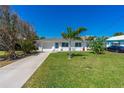 Well-maintained home with a manicured lawn, mature trees, and a convenient driveway at 129 Dundee Rd, Daytona Beach, FL 32118