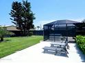 Private backyard with patio, hot tub, screened enclosure, and mature trees at 13 Sunrise Ave, Ormond Beach, FL 32176