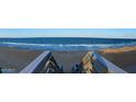 Breathtaking panoramic beach view with rolling waves, wooden staircase, and blue skies at 13 Sunrise Ave, Ormond Beach, FL 32176