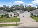 Beautiful home featuring a three-car garage, manicured lawn, and bright exterior paint at 3029 Adrian Dr, Ormond Beach, FL 32174
