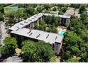 Aerial view of the condominium featuring a pool, landscaping, and multiple roof top air conditioning units at 640 N Nova Rd # 117, Ormond Beach, FL 32174