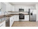 Bright kitchen featuring white cabinets, stainless steel appliances, and a granite countertop at 807 Scrub Oak St, South Daytona, FL 32119