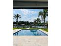Beautiful pool with waterfront views, palm trees, and a boat dock for serene outdoor living at 992 Shockney Dr, Ormond Beach, FL 32174