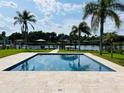 Sparkling pool with serene water views, framed by palm trees and lush greenery at 992 Shockney Dr, Ormond Beach, FL 32174