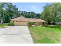 Well-maintained home with a lush front lawn and mature trees, with an attached two-car garage at 2270 Wilmhurst Rd, Deland, FL 32720