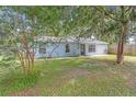 Charming single-story blue home with a well-maintained lawn and mature trees in a serene setting at 7686 Sw 81St St, Ocala, FL 34476