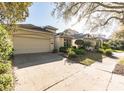 Well-kept single story house showcasing a spacious driveway and beautifully landscaped front yard at 902 Heron Point Cir, Deland, FL 32724