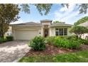 Inviting single-story home featuring a two-car garage and lush, green landscaping at 902 Heron Point Cir, Deland, FL 32724