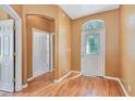 Bright foyer featuring wood floors, arched transom, and a decorative glass front door at 902 Heron Point Cir, Deland, FL 32724