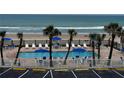 Outdoor pool area with palm trees, lounge chairs, and beach views for ultimate relaxation and resort-style living at 1233 S Atlantic Ave # 3070, Daytona Beach, FL 32118