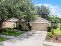 Lovely home with a well-maintained lawn, a two-car garage, and manicured landscaping at 25216 Ironwedge Dr, Sorrento, FL 32776