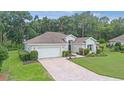 Well-maintained home with a paved driveway, attached garage, and carefully landscaped front yard at 11616 Sw 75Th Cir, Ocala, FL 34476