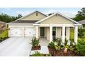 Charming home featuring a manicured lawn, covered porch, and a two-car garage, creating a welcoming curb appeal at 2861 Monaghan Dr, Ormond Beach, FL 32174