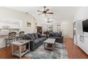 Spacious living room featuring hardwood floors, vaulted ceilings, comfortable seating, and views into the kitchen and dining area at 2910 Yule Tree Dr, Edgewater, FL 32141
