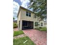 Back exterior view of home showing a screened-in porch and brick-paved patio at 3660 Daydream Pl, St Cloud, FL 34772