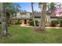 Charming home featuring a stone facade, well-manicured lawn, and inviting landscaping at 428 Pelican Bay Dr, Daytona Beach, FL 32119