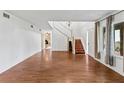 Bright living room with hardwood floors, staircase, and stone fireplace in background at 428 Pelican Bay Dr, Daytona Beach, FL 32119