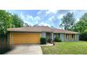 Charming single-story home with well-maintained lawn and vibrant, painted yellow garage door at 1561 Copperfield Ave, Deltona, FL 32738