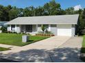 Well-maintained single-story home with attached garage, concrete driveway, and landscaped front yard at 1810 Western Rd, South Daytona, FL 32119