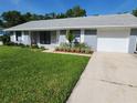 Well-kept single-story home featuring an attached garage, a pristine lawn, and a concrete driveway at 1810 Western Rd, South Daytona, FL 32119