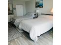 Bright bedroom featuring two beds, wood-look floors, and a calming color palette at 1909 S Atlantic Ave # 405/406, Daytona Beach Shores, FL 32118