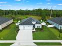 Stunning aerial view of a well-maintained home with a large driveway and beautiful backyard landscaping at 2137 Raglan Cir, Ormond Beach, FL 32174