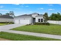 Attractive one-story home with a three-car garage, complemented by lush lawn and mature landscaping at 2137 Raglan Cir, Ormond Beach, FL 32174
