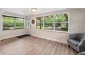 Cozy living room featuring light wood floors, neutral walls, and a large window with backyard views at 21375 Nw 150Th Avenue Rd, Micanopy, FL 32667