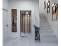 Bright hallway featuring stairs, a lift, and modern art on the marble floor at 2360 Ocean Shore Blvd # 2, Ormond Beach, FL 32176