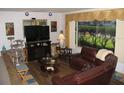 Cozy living room with a fireplace, plush seating, and a large window overlooking the yard at 39 Benjamin Dr, Ormond Beach, FL 32176