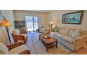 Cozy living room with comfortable seating, sliding glass doors, and beach-inspired decor at 4155 S Atlantic Ave # 204, New Smyrna Beach, FL 32169
