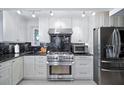 Modern kitchen with stainless steel appliances, custom white cabinetry, and black marble countertops at 1108 Shockney Dr, Ormond Beach, FL 32174
