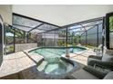 A screened-in pool and spa area offers a relaxing outdoor experience with comfortable seating at 1108 Shockney Dr, Ormond Beach, FL 32174