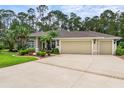 Spacious home exterior featuring a three-car garage, driveway, and meticulously maintained landscaping at 1254 Royal Pointe Ln, Ormond Beach, FL 32174