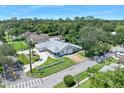 Aerial view of charming single-story home with a gray roof, circular driveway, and landscaped front yard in a neighborhood at 1650 Riverside Dr, Daytona Beach, FL 32117