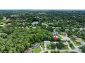 Aerial view of a home nestled in a lush, wooded community with a nearby lake at 24 Katrinas Dr, Ormond Beach, FL 32174