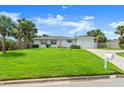 Inviting single-story home with a well-kept lawn, complemented by lush palm trees and an attached garage at 1026 Bel Aire Dr, Daytona Beach, FL 32118