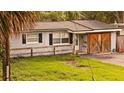 Charming single-story home featuring fresh paint, tidy front yard, and wooden garage doors at 1131 Martha Dr, Daytona Beach, FL 32114