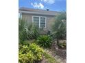 Exterior view of the home's side, with lush landscaping and an A/C unit at 1218 Daytona Ave, Daytona Beach, FL 32117